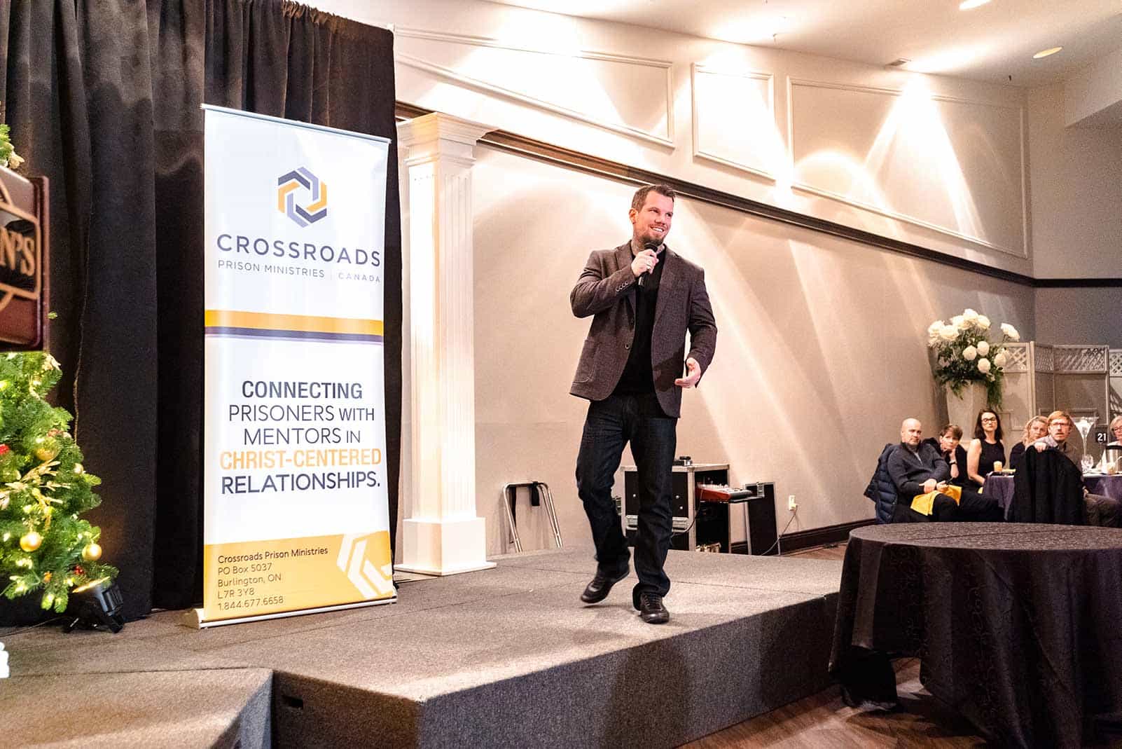 Cody Bates paces the stage in front of a Crossroads poster